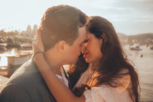 Ein Paar umarmt sich innig und berührt sich mit den Stirnen, als Symbol für körperliche Nähe, Sexualität und Intimität in der Partnerschaft.